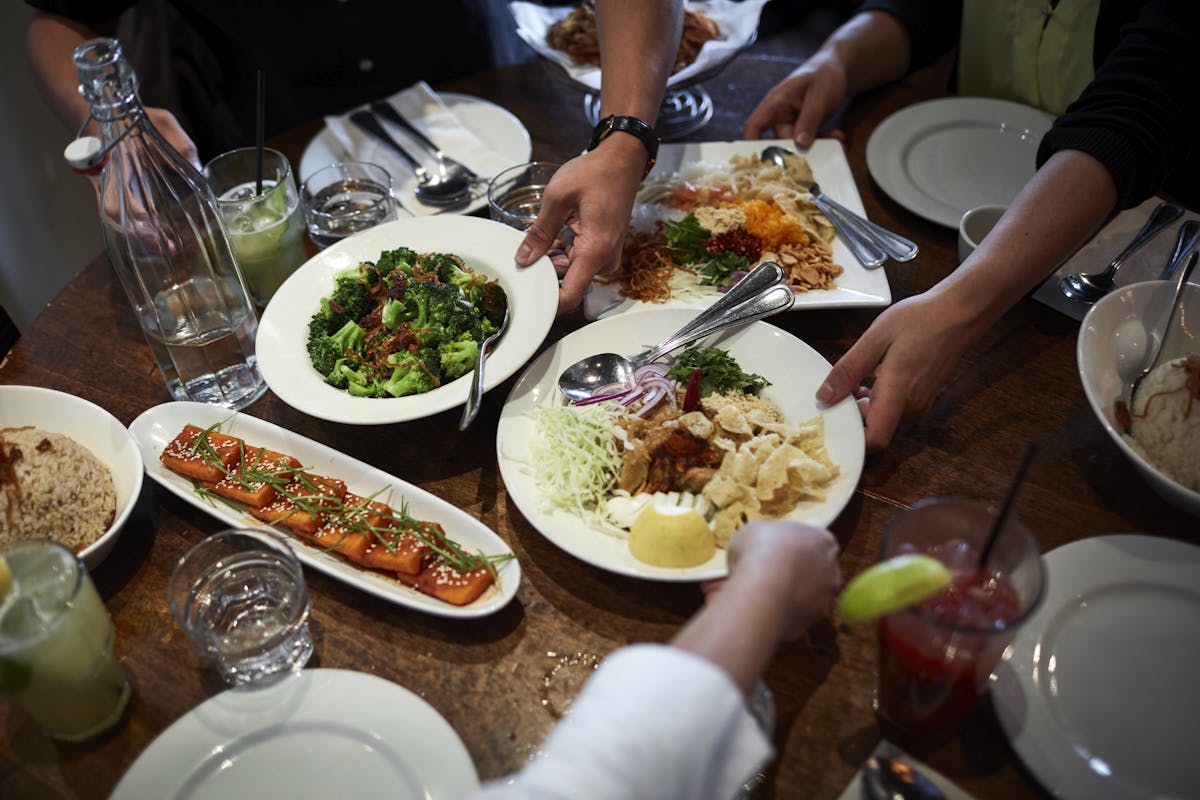 a group of people sitting at a table with a plate of food