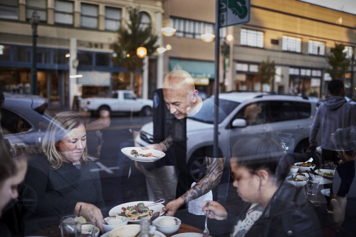 a group of people sitting at a table eating food