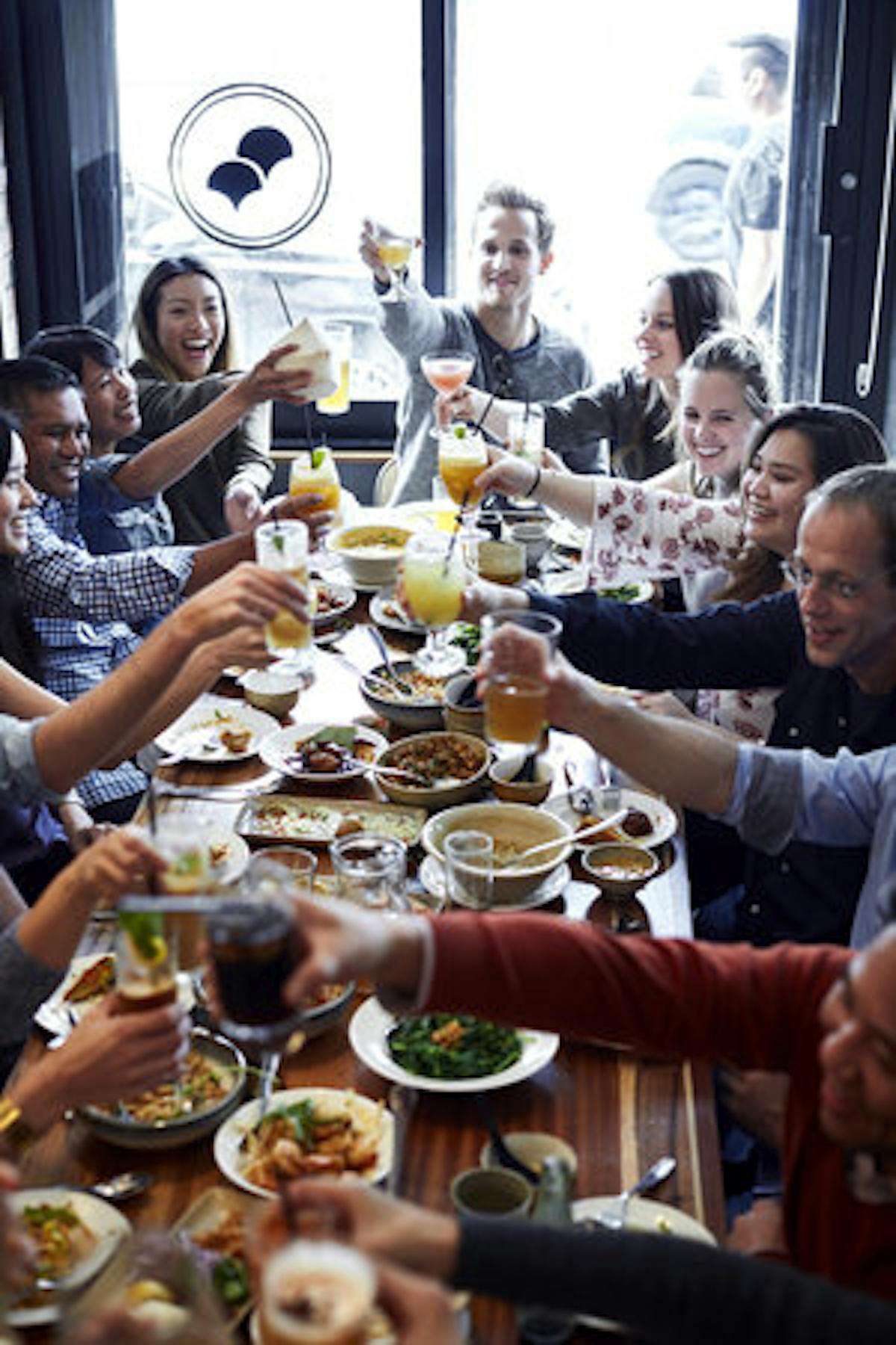 a group of people sitting at a table with food