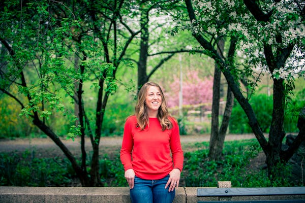 a person in a red shirt standing in front of a tree