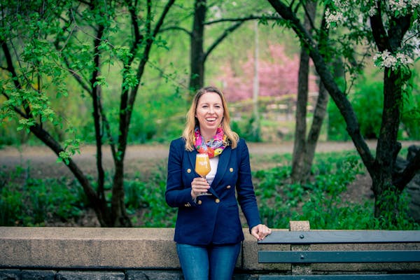 a woman sitting on a bench in front of a tree