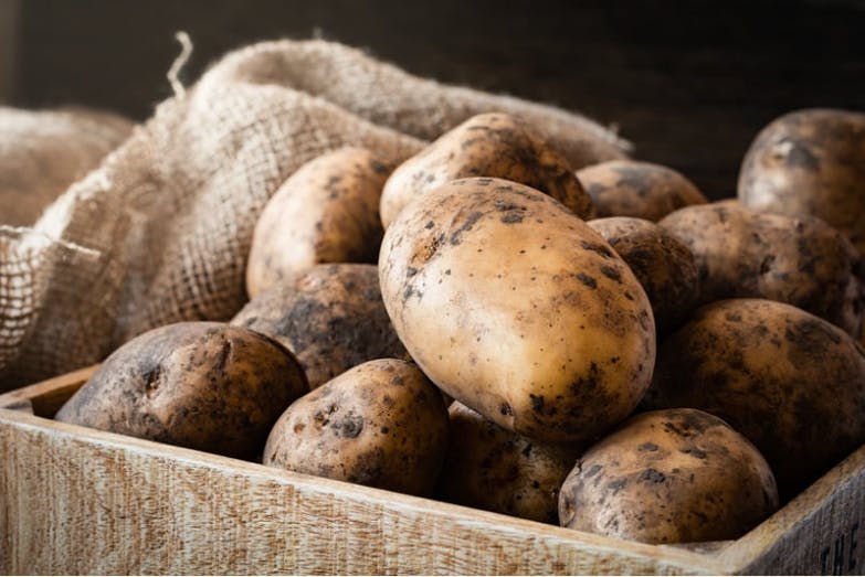 a group of potatoes in a wooden box