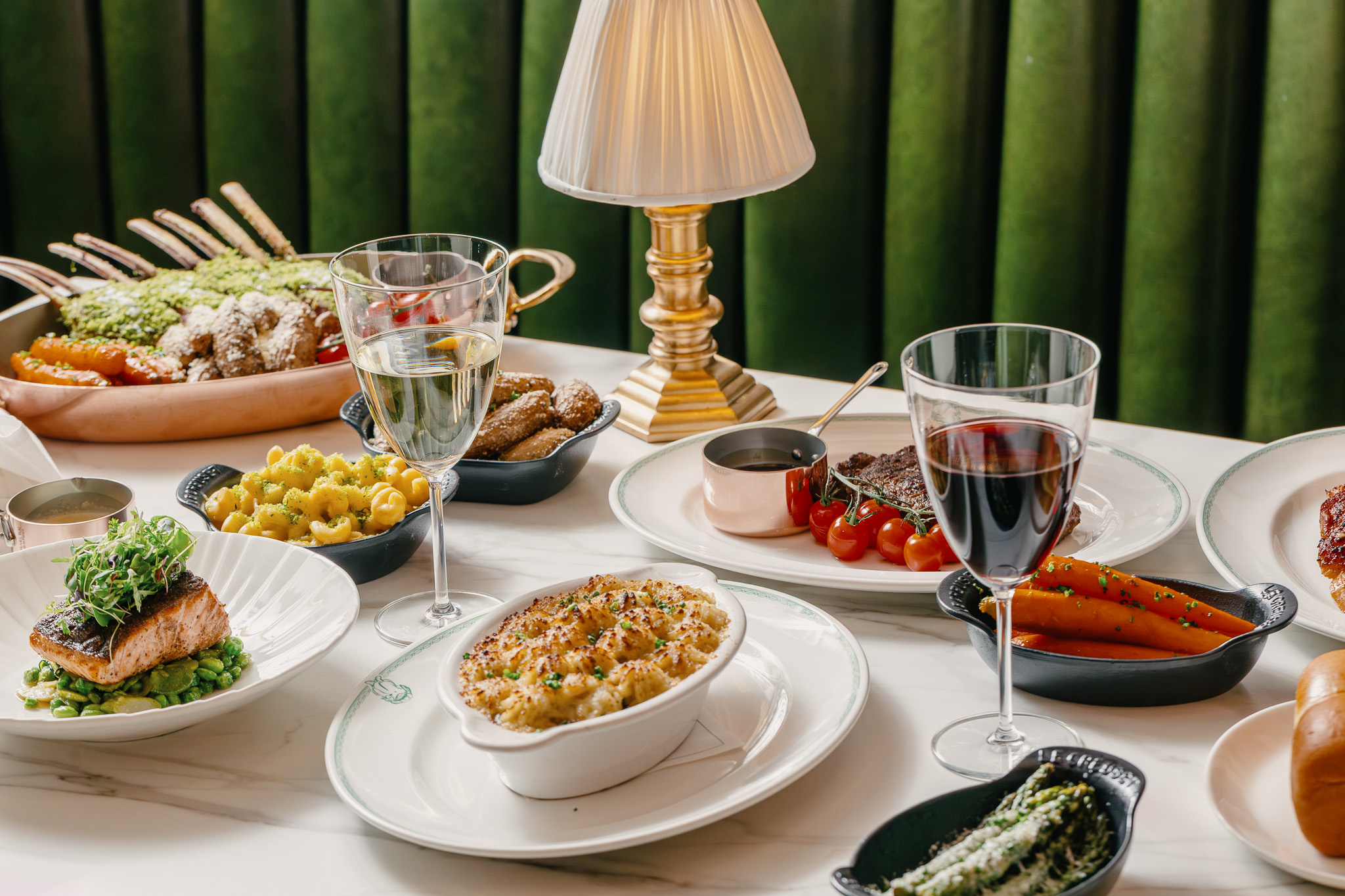 a table with plates of food and glasses of wine