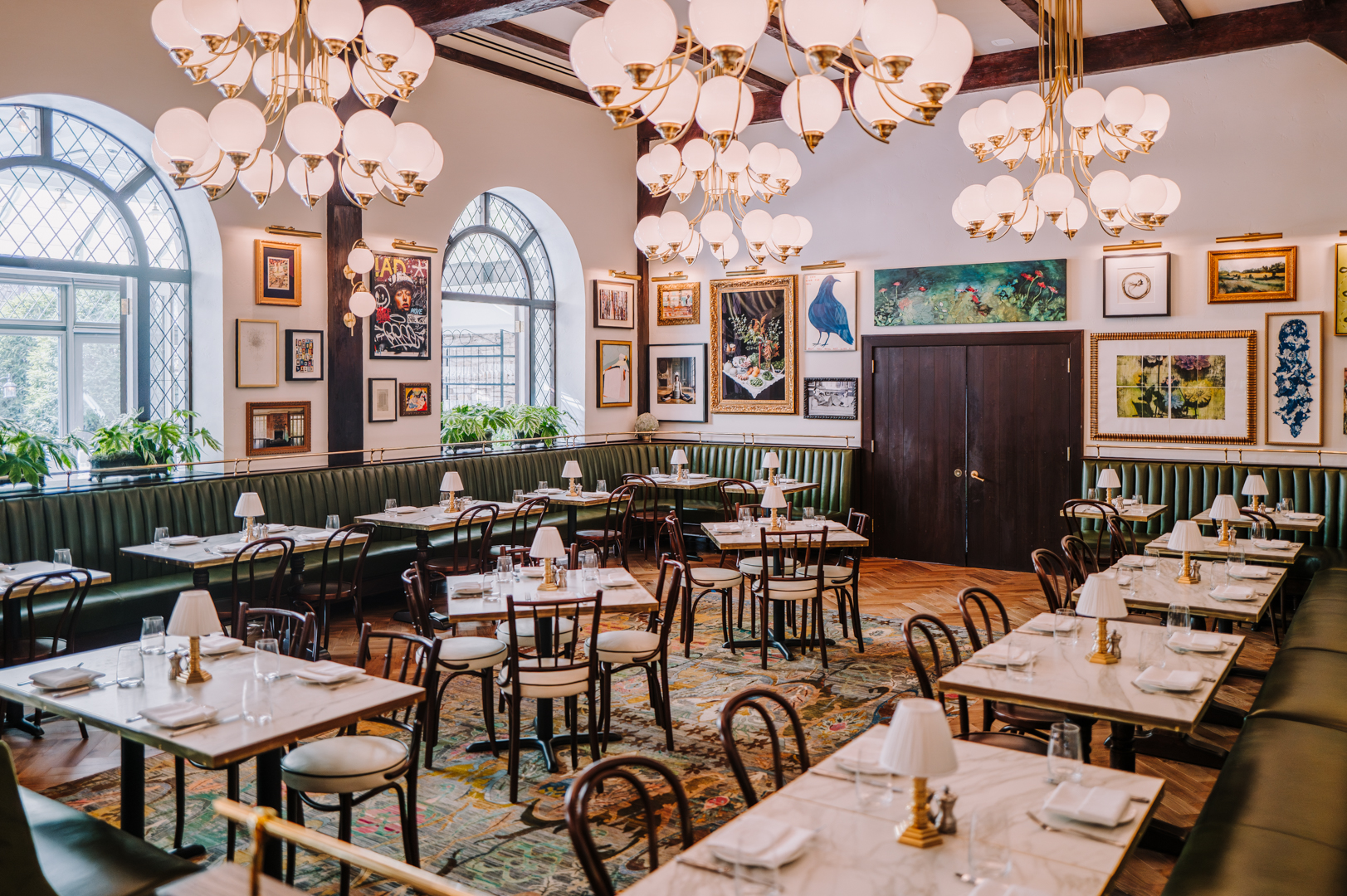 a room with tables and chairs and chandeliers