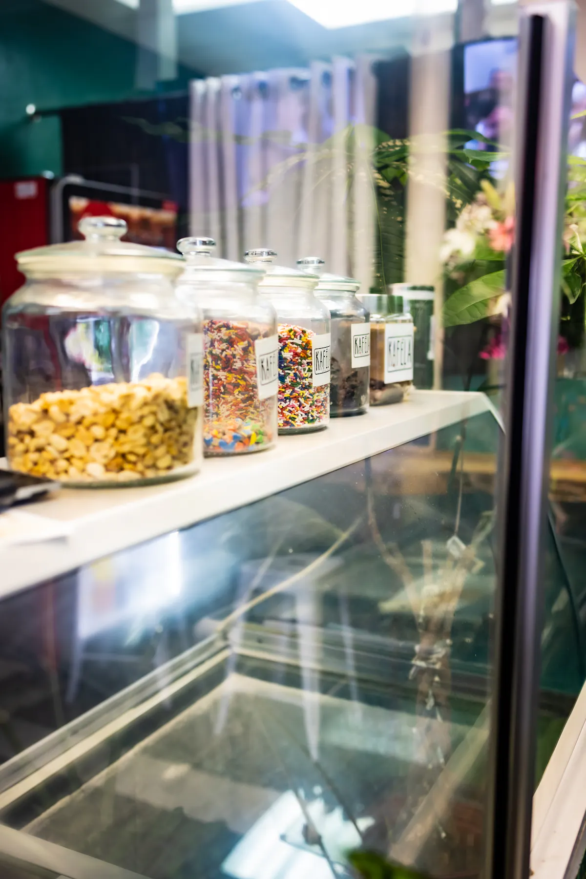 a close up of five big glass jars of various tops