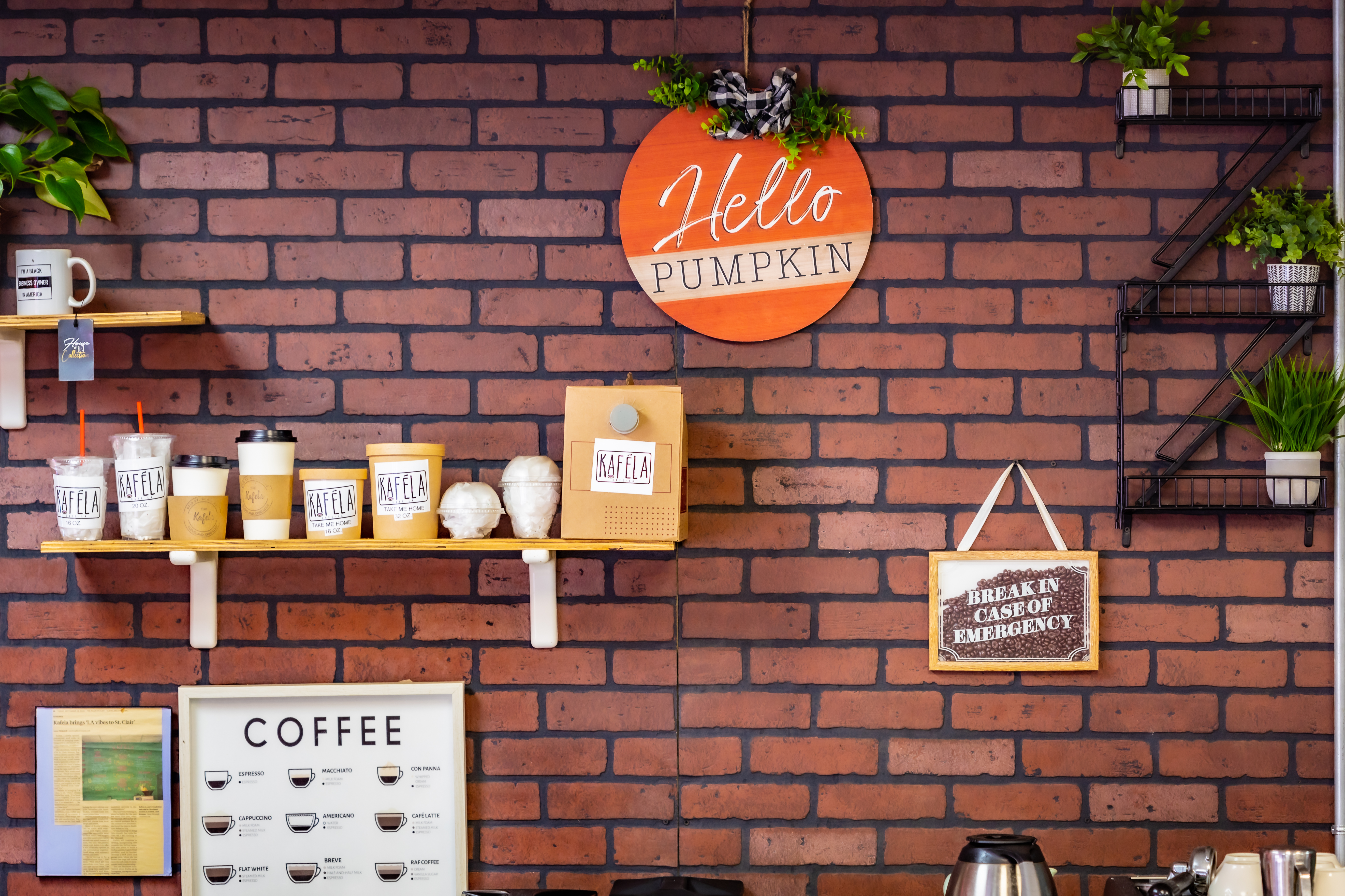 a brick backdrop of on side of the interior of kafela with shelves of kafela products
