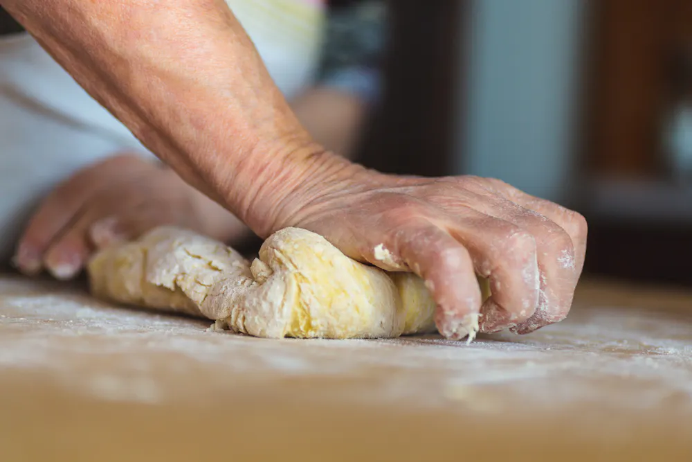 a person's hands kneading dough