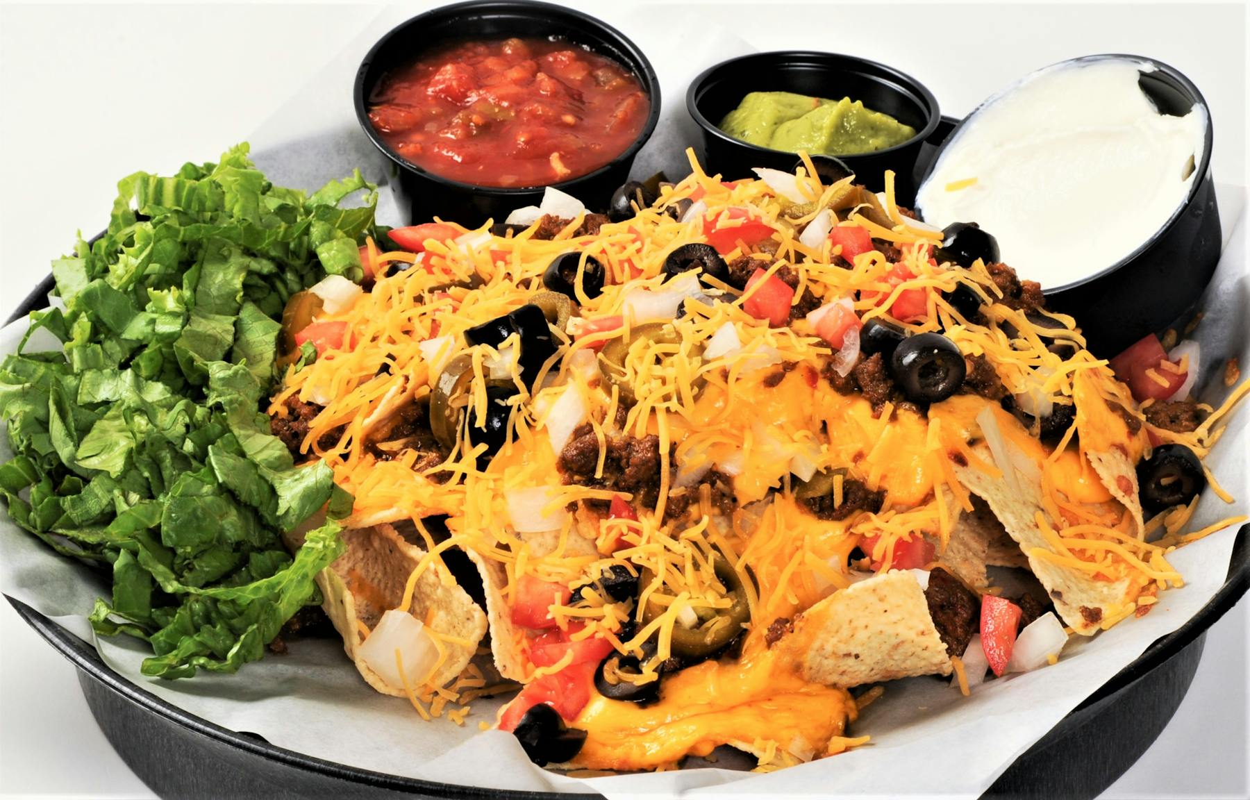 a white plate topped by nachos and salsa