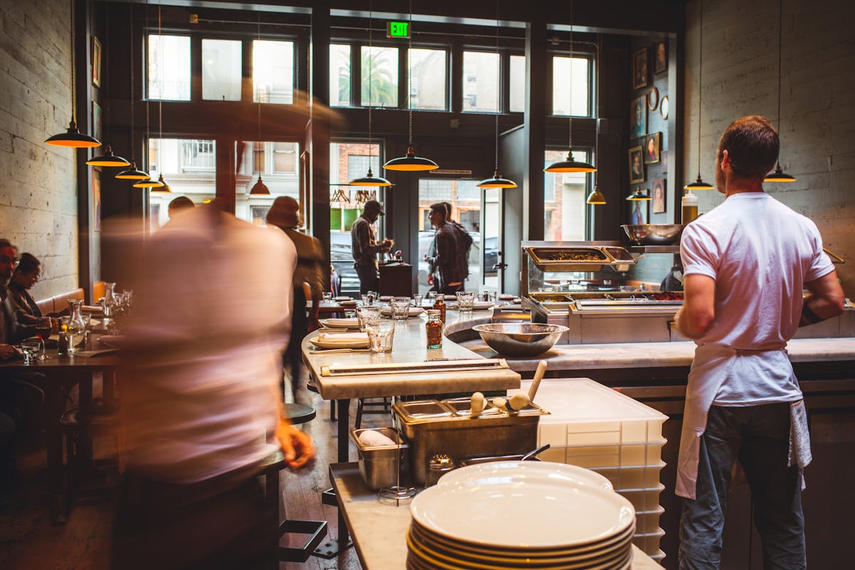 a group of people standing in a kitchen preparing food