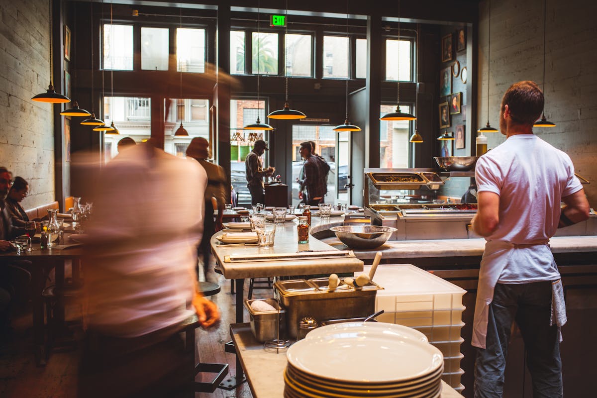 a group of people standing in a kitchen preparing food