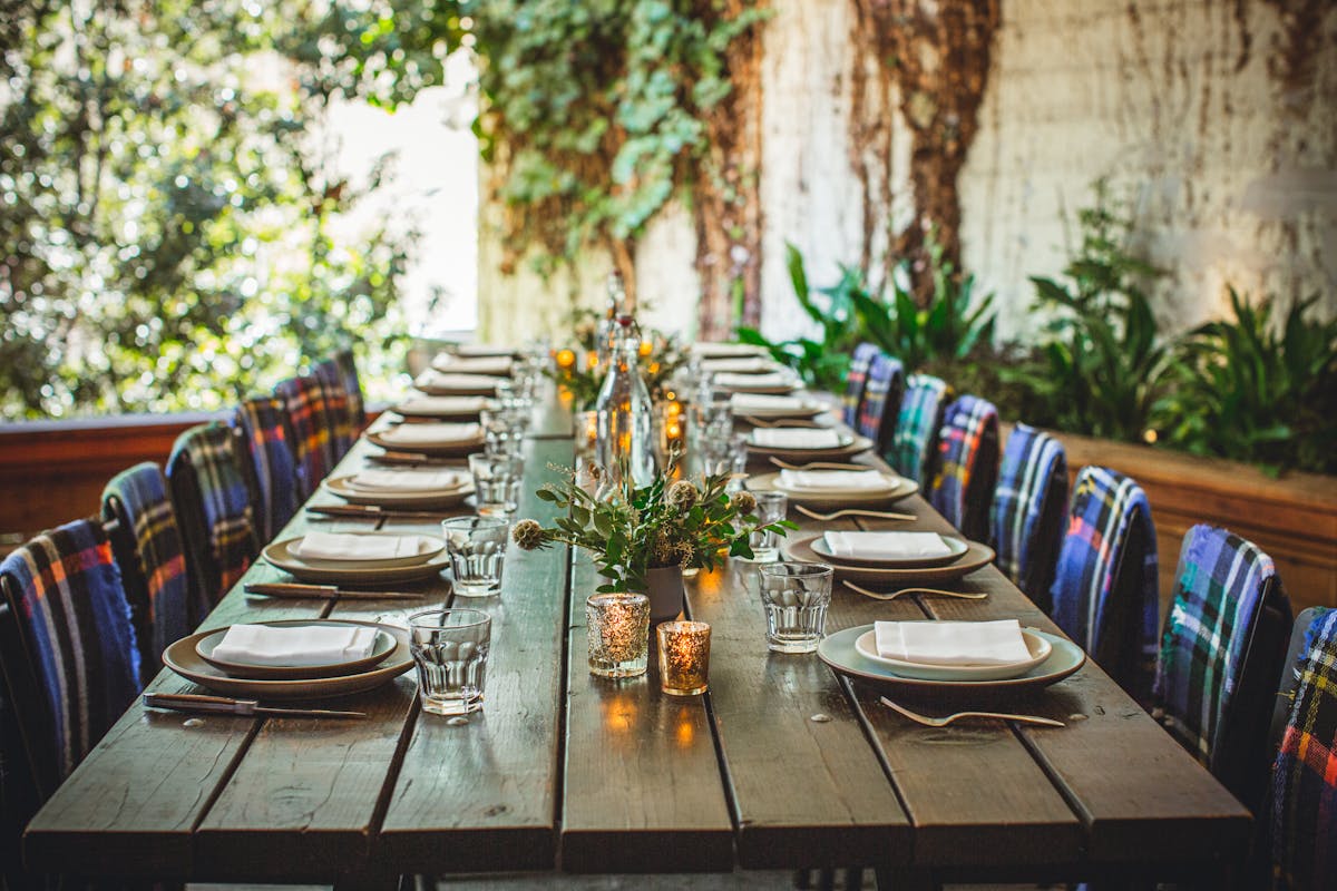 a wooden dining table filled with wine glasses