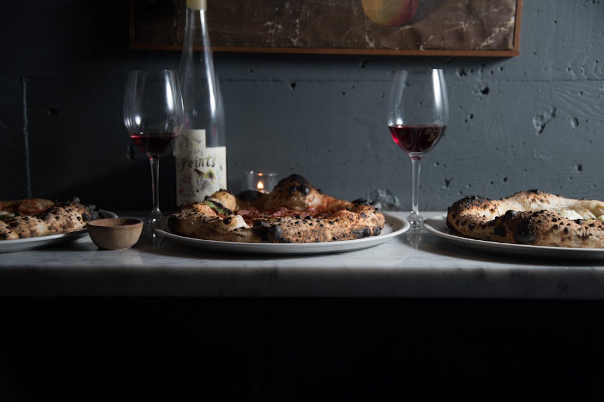 a plate with a pizza and a glass of wine 