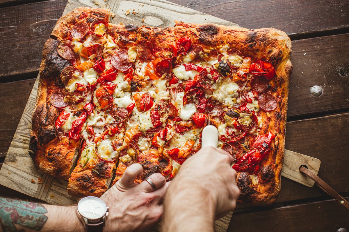 a pizza sitting on top of a wooden cutting board