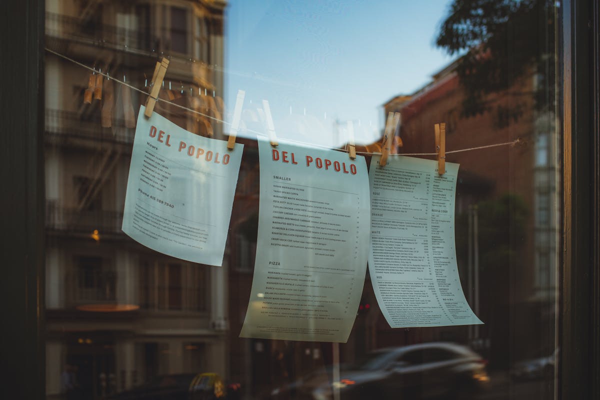a string with the menus hanging on the restaurant window 