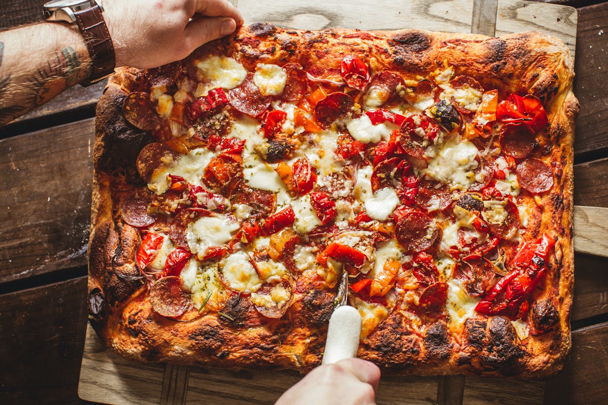 a pizza sitting on top of a wooden table