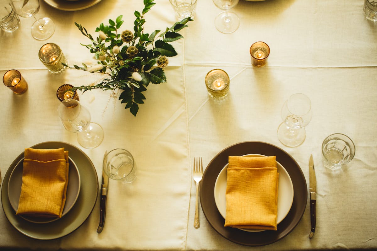 a table sit set with plate and candles 