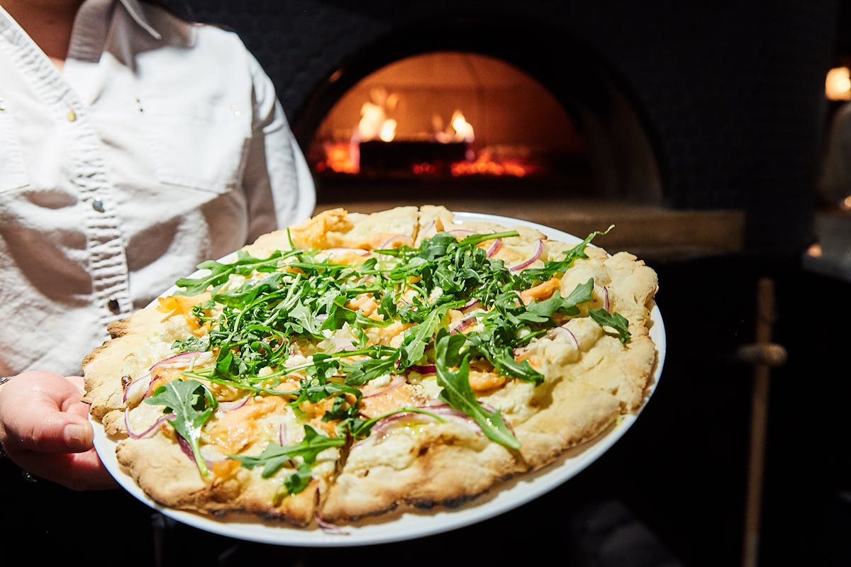 a person holding a pizza