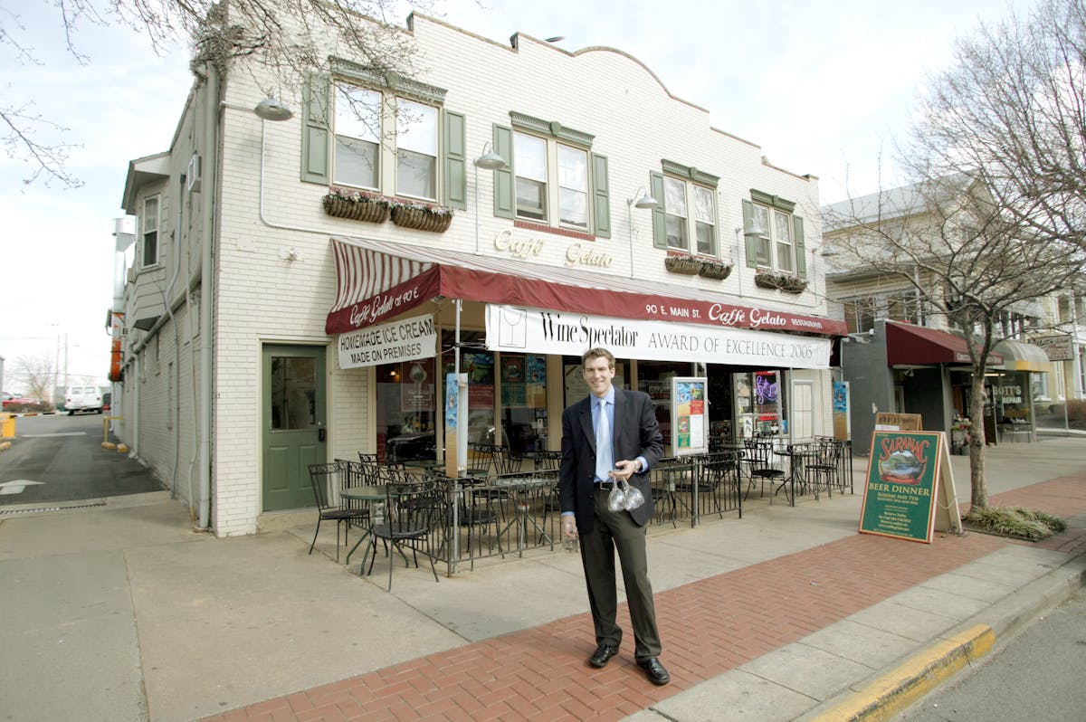 a person walking down a sidewalk in front of a building