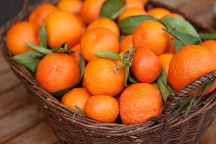 a bowl of oranges on a table