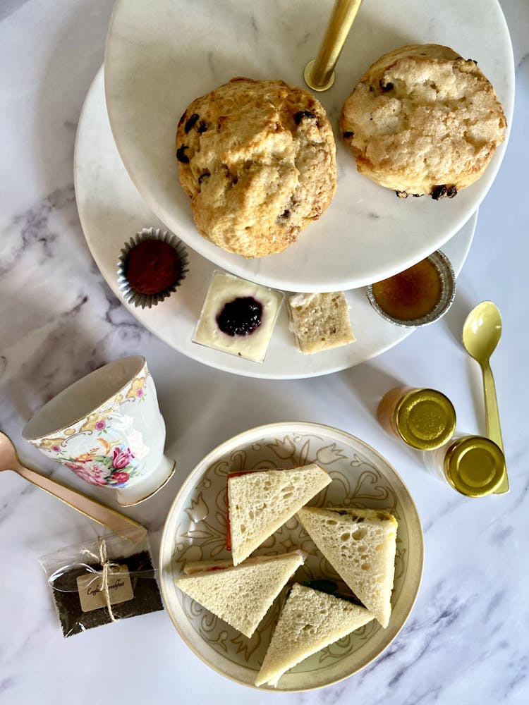 scones tea petit fours and tea sandwiches laid out on a table