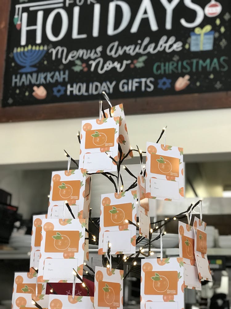 a close up of clementine gift cards on a holiday tree