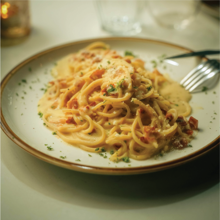 a bowl of pasta sits on a plate