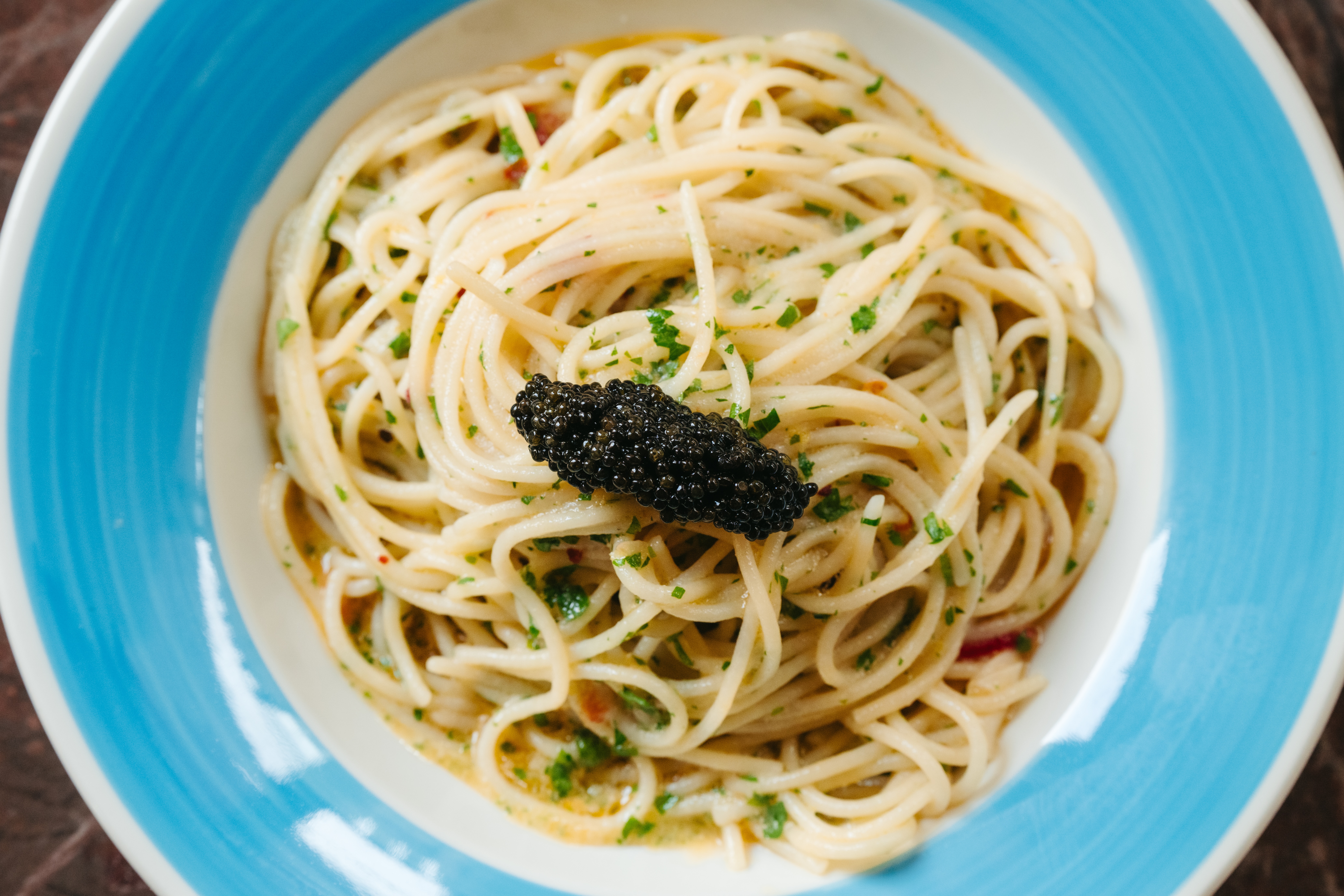 a bowl of spaghetti with caviar on top