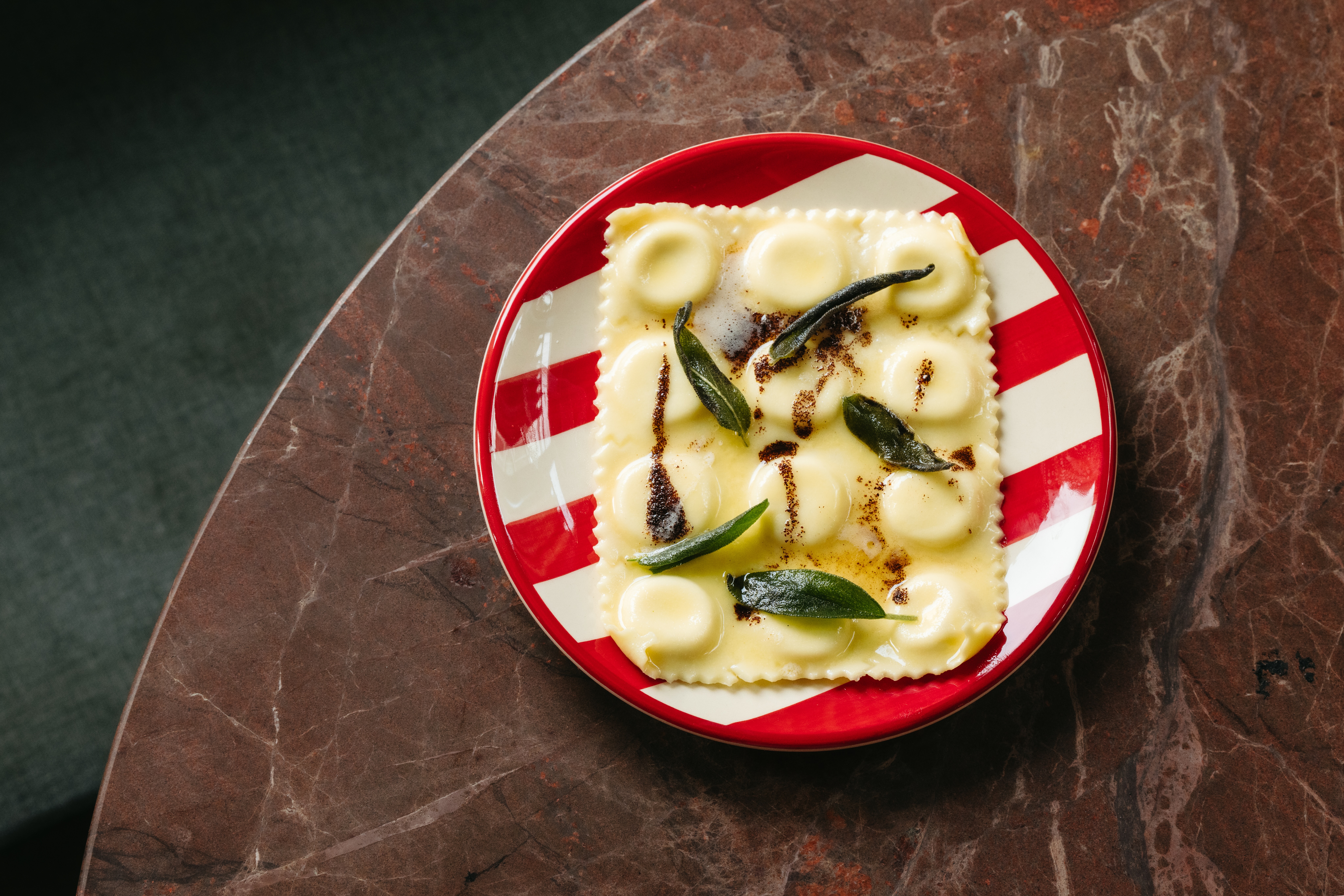 a plate of ravioli with leaves on it