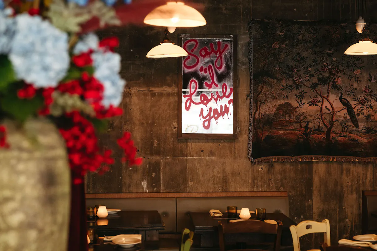 a room with tables and chairs and a painting on the wall