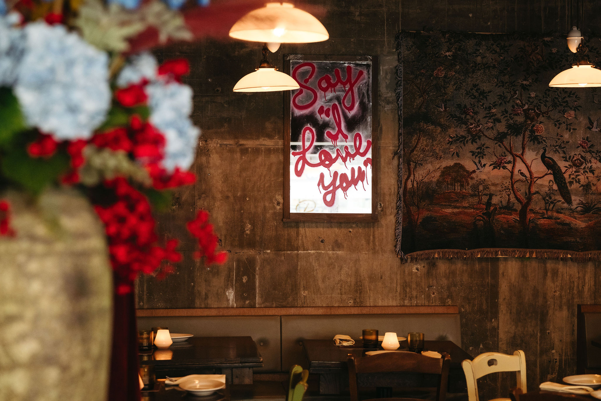 a room with tables and chairs and a painting on the wall