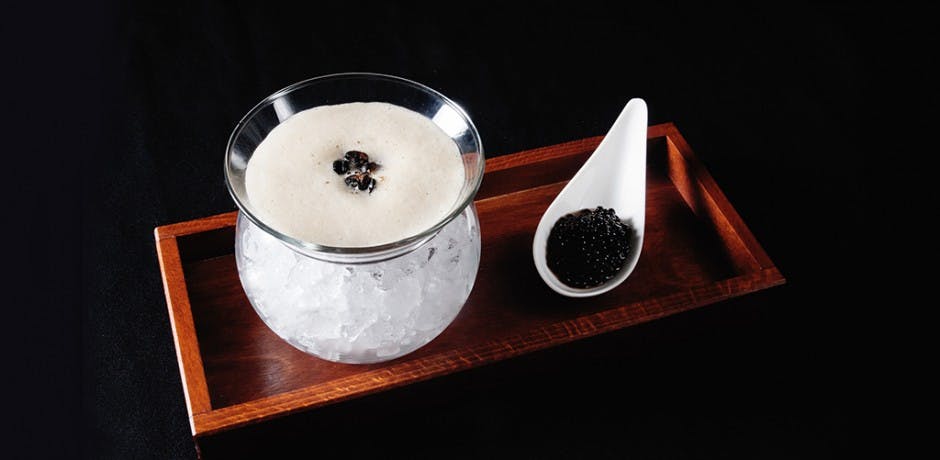 a bowl filled with milk sided by a spoon of coffee