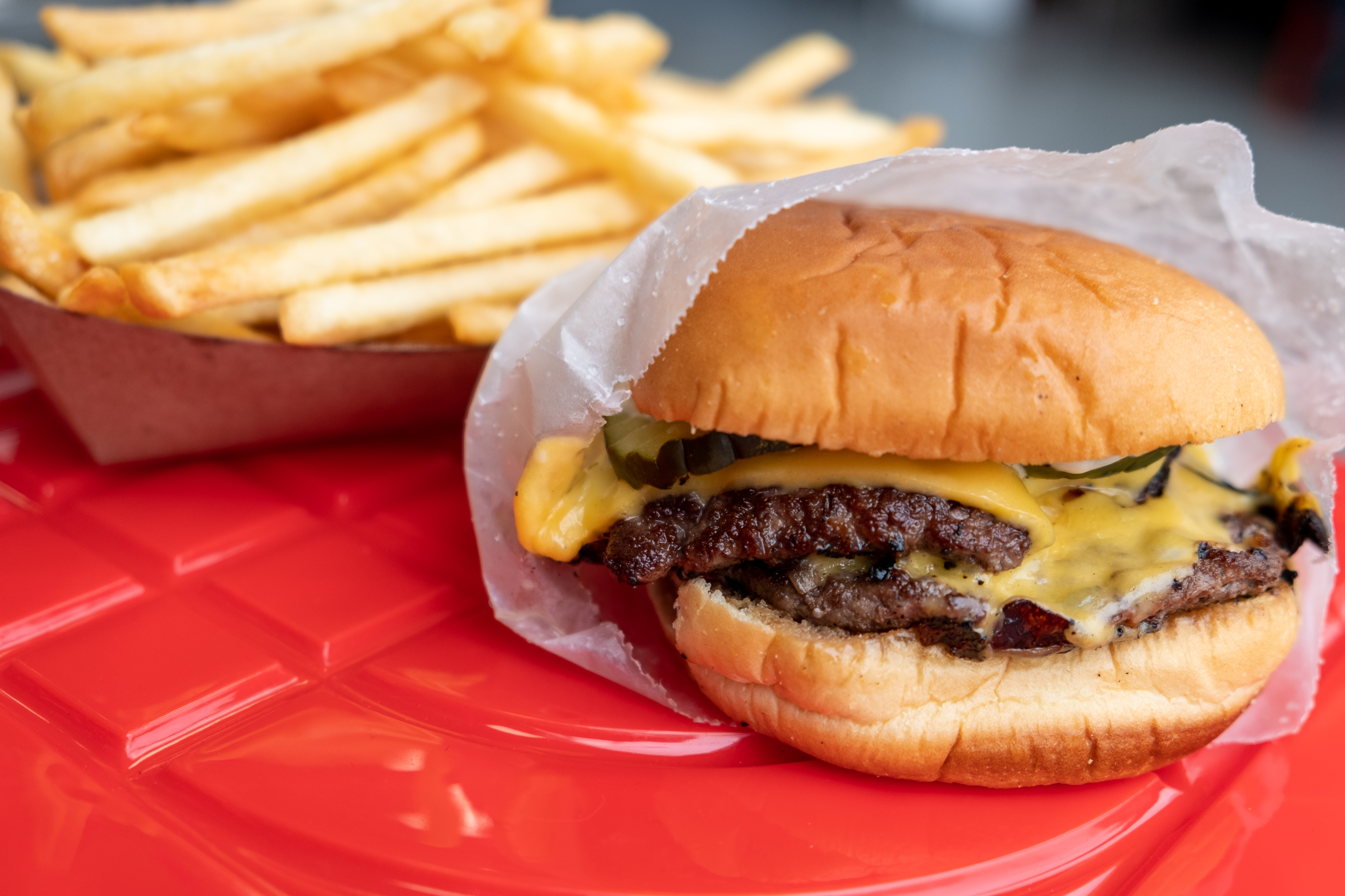 a sandwich sitting on top of a bun next to some fries