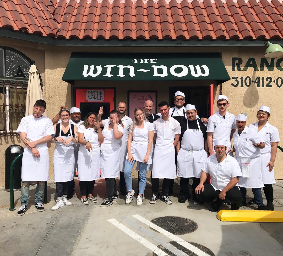 a group of people in white aprons posing for a photo