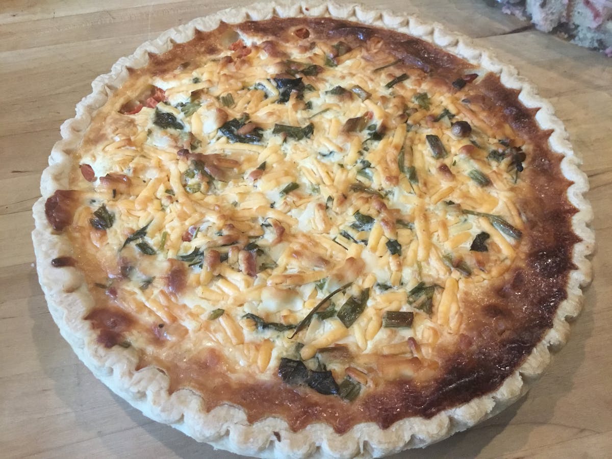 a pizza sitting on top of a wooden cutting board