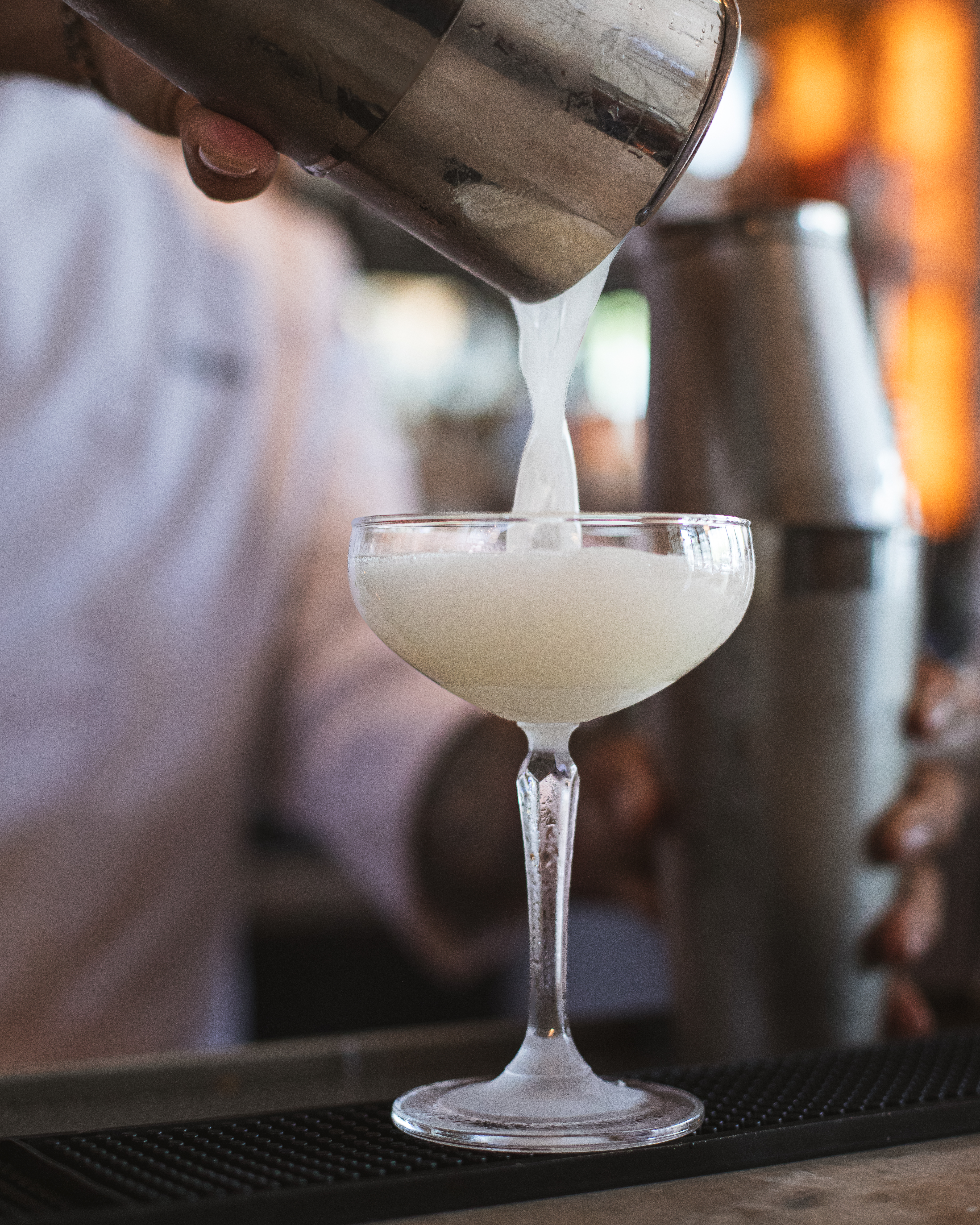 a person pouring a drink into a glass