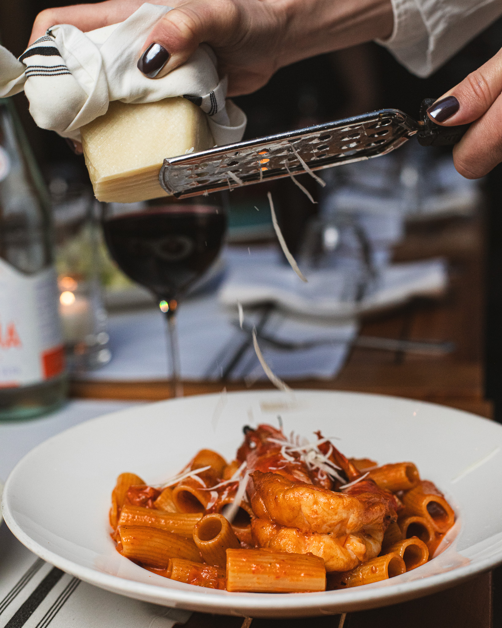 a person holding a plate of food on a table
