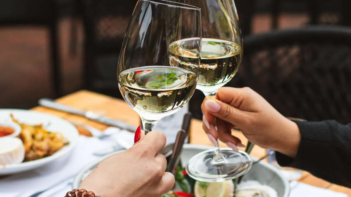 two hands holding wine glasses