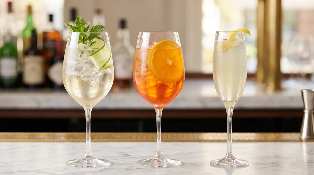 a group of wine glasses with different colored drinks