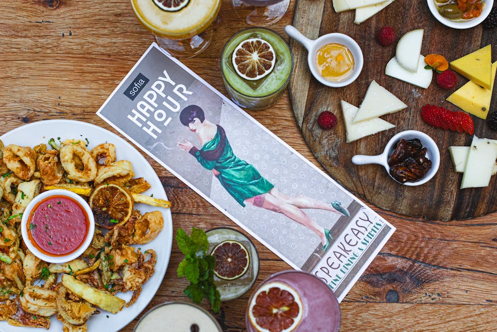 a person holding a glass of beer on a table