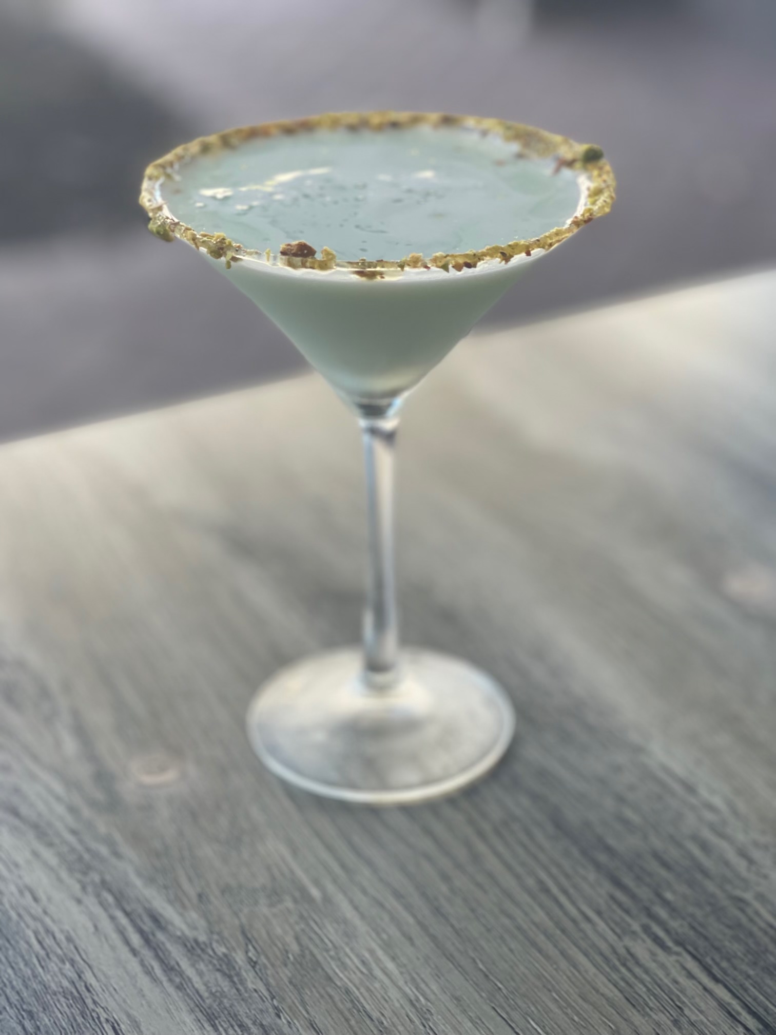 a glass of wine sitting on top of a wooden table