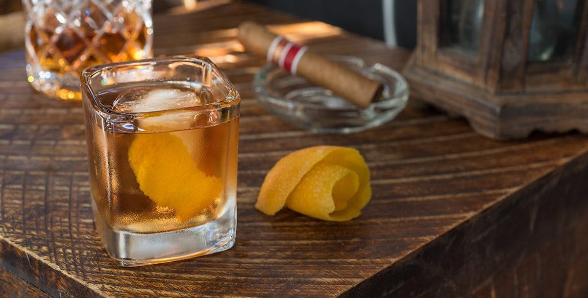 a glass of wine sitting on top of a wooden cutting board