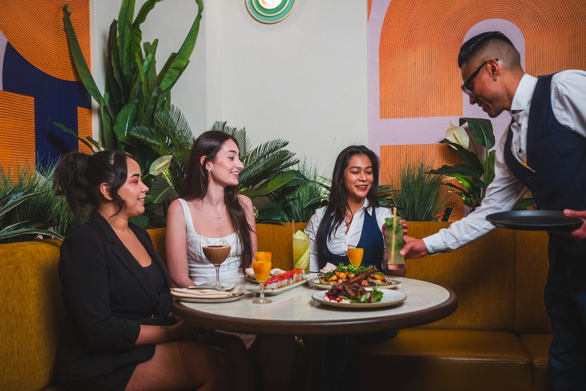 a group of people sitting at a table with a cake