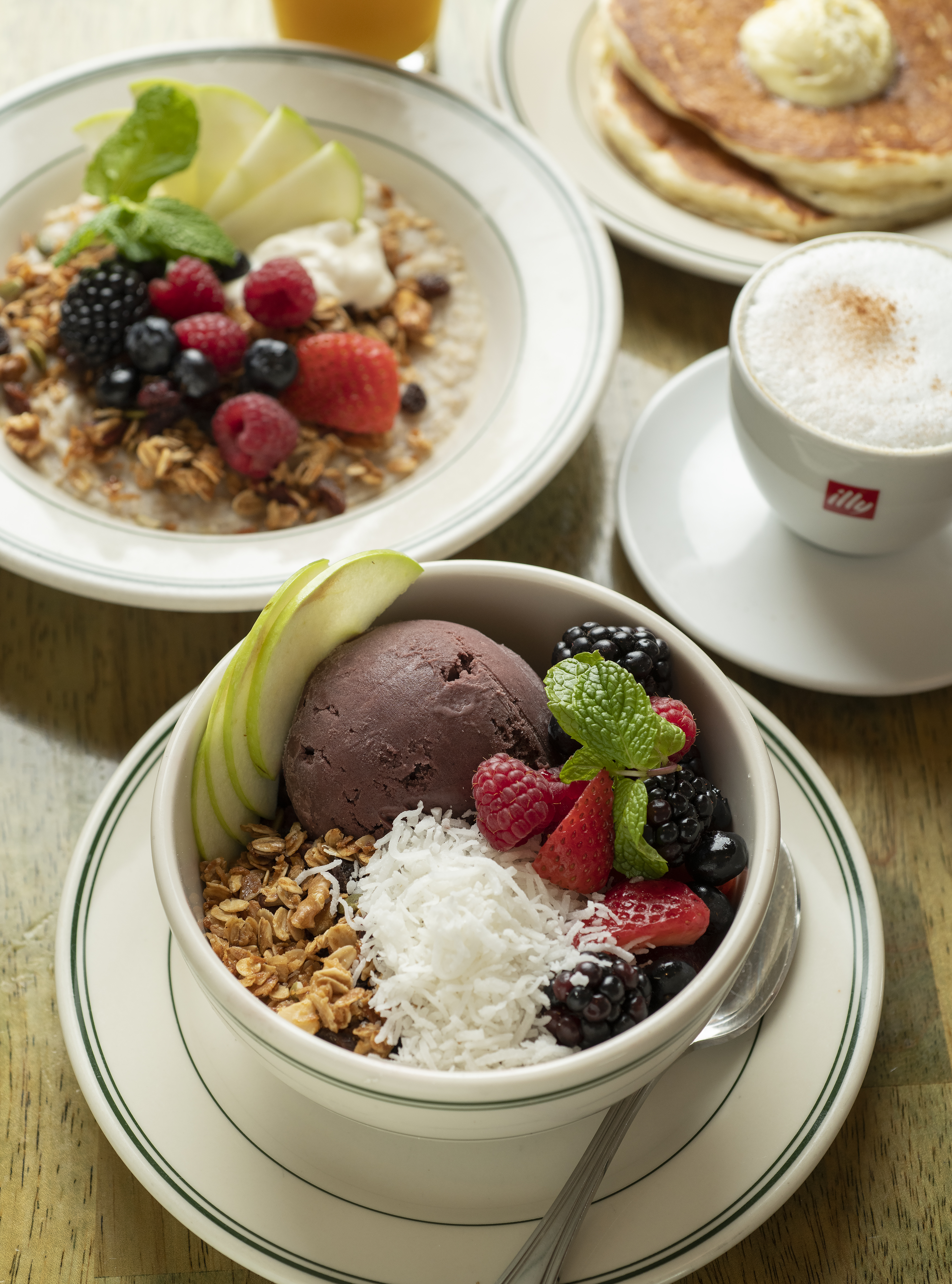 a bowl of fruit and oatmeal with a cup of coffee