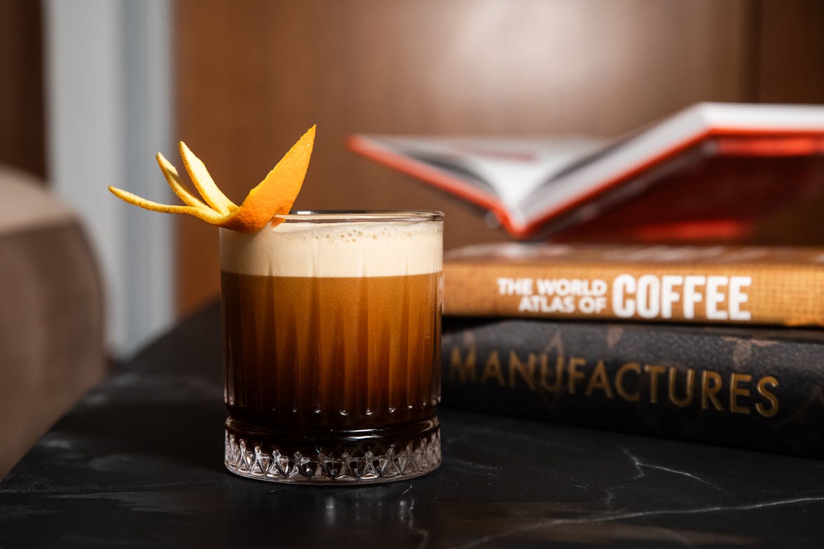 a cup of coffee sitting next to a glass of orange juice
