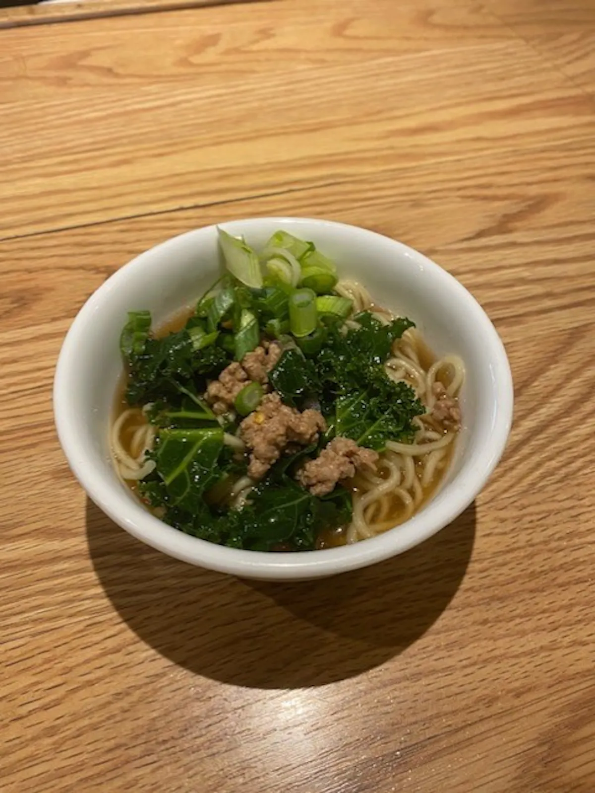 a bowl of broccoli sitting on top of a wooden table