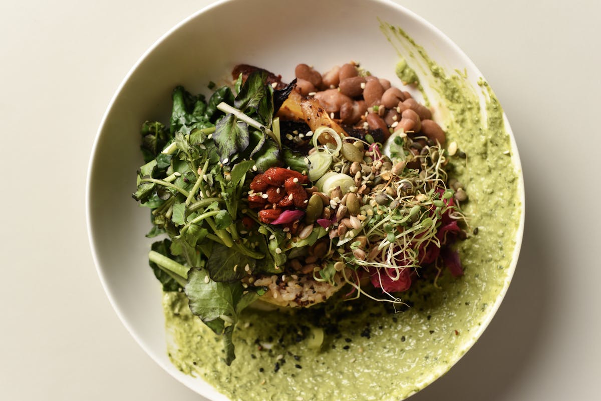 vegetable forward buddha bowl on table with utensils