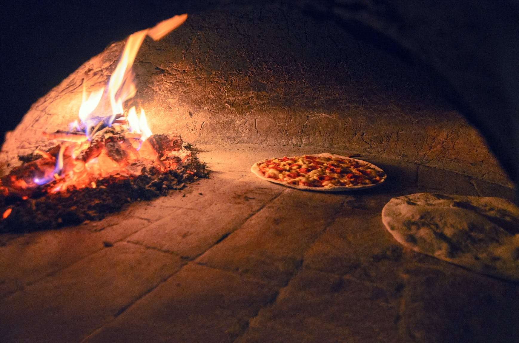 a pizza sitting on top of a fire oven