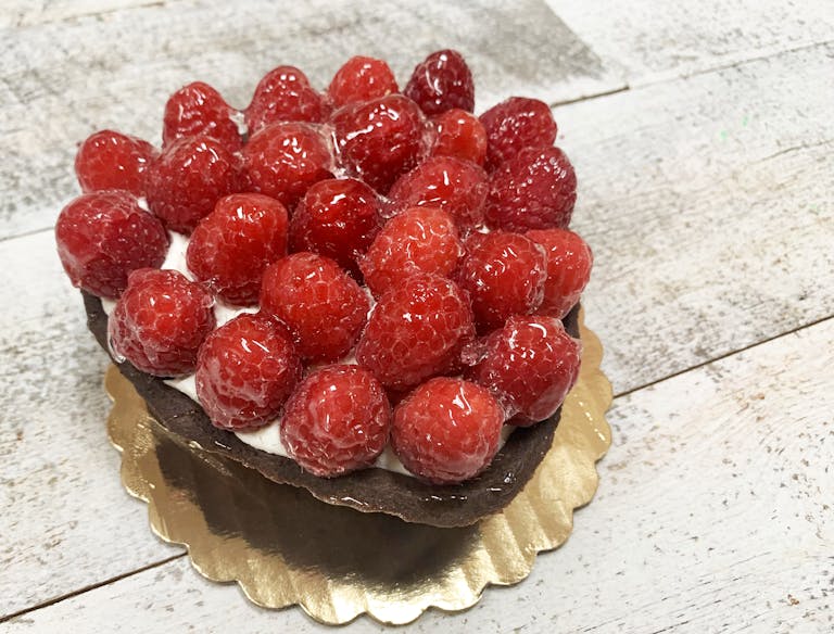 Heart-shaped chocolate tar shell, filled with mascarpone cream and topped with fresh raspberries