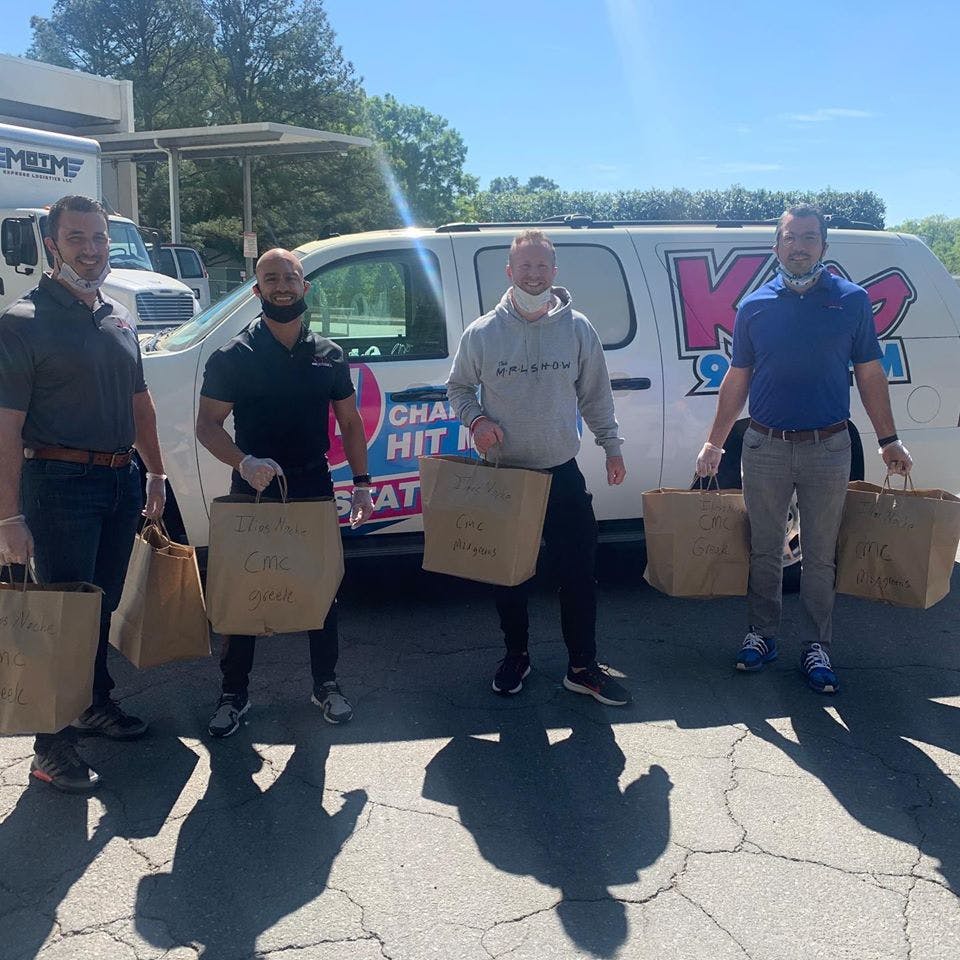 a group of people standing in a parking lot