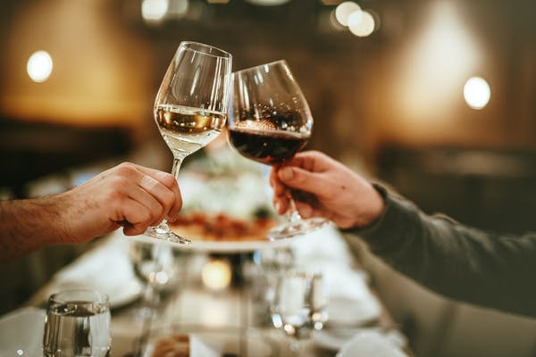 a person sitting at a table with wine glasses